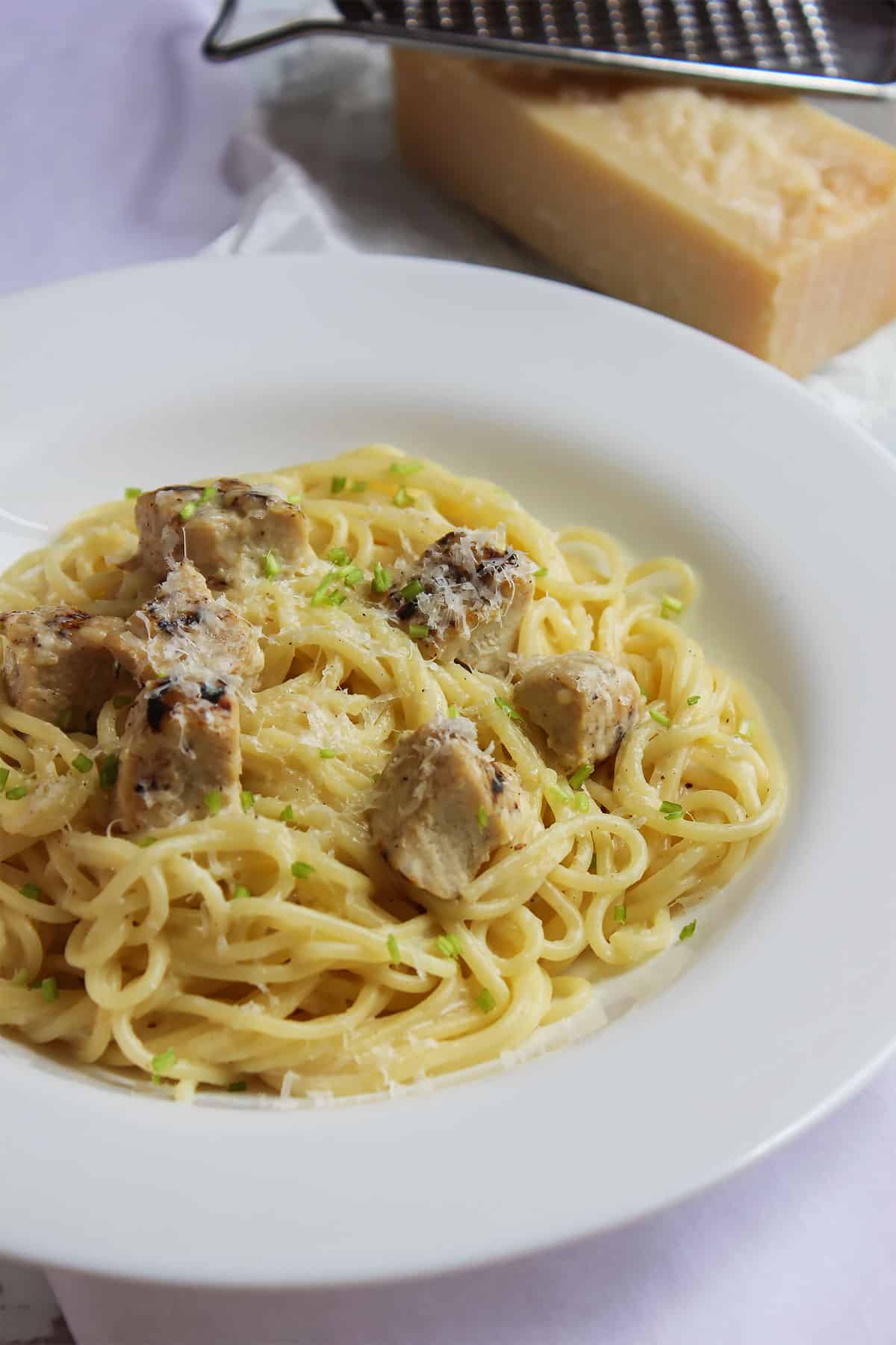 low calorie chicken alfredo served in a white plate.