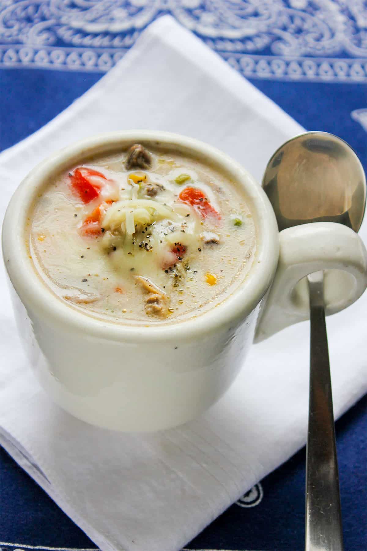 chicken and vegetable soup a creamy soup, served in a white cup.