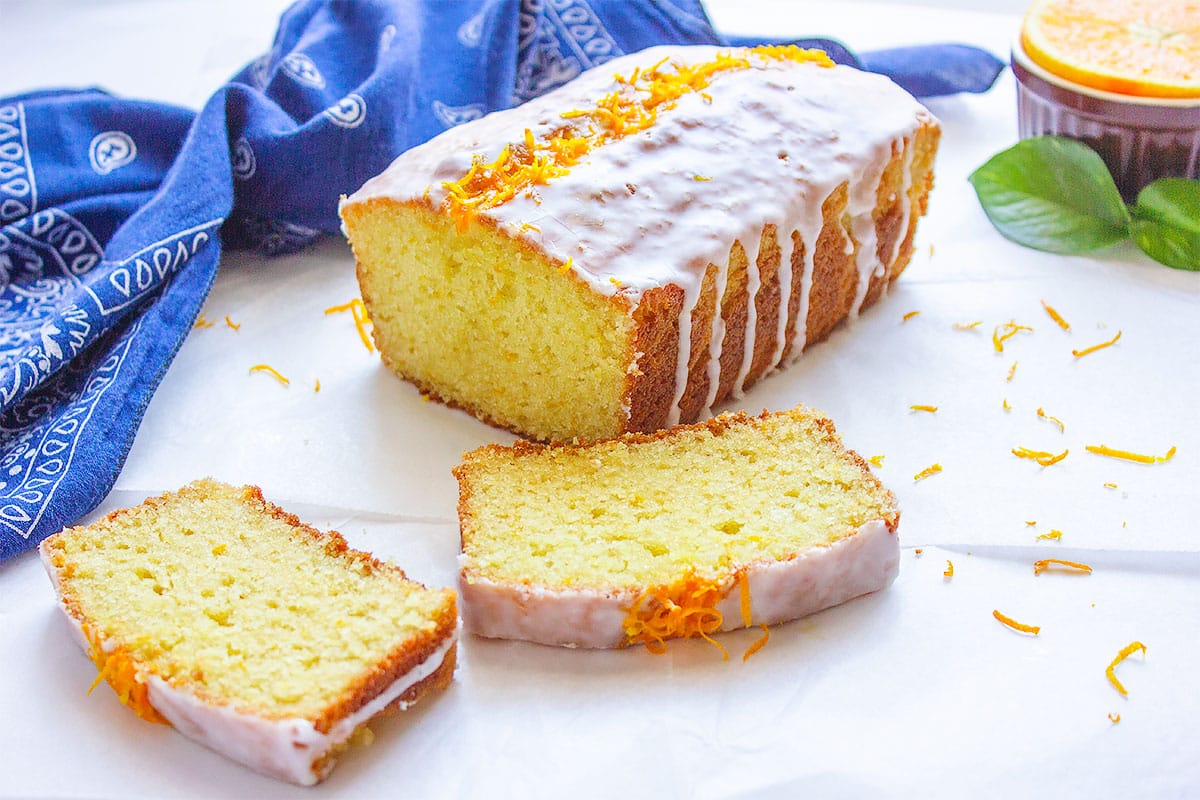 Orange sour cream cake with two slices on the side.