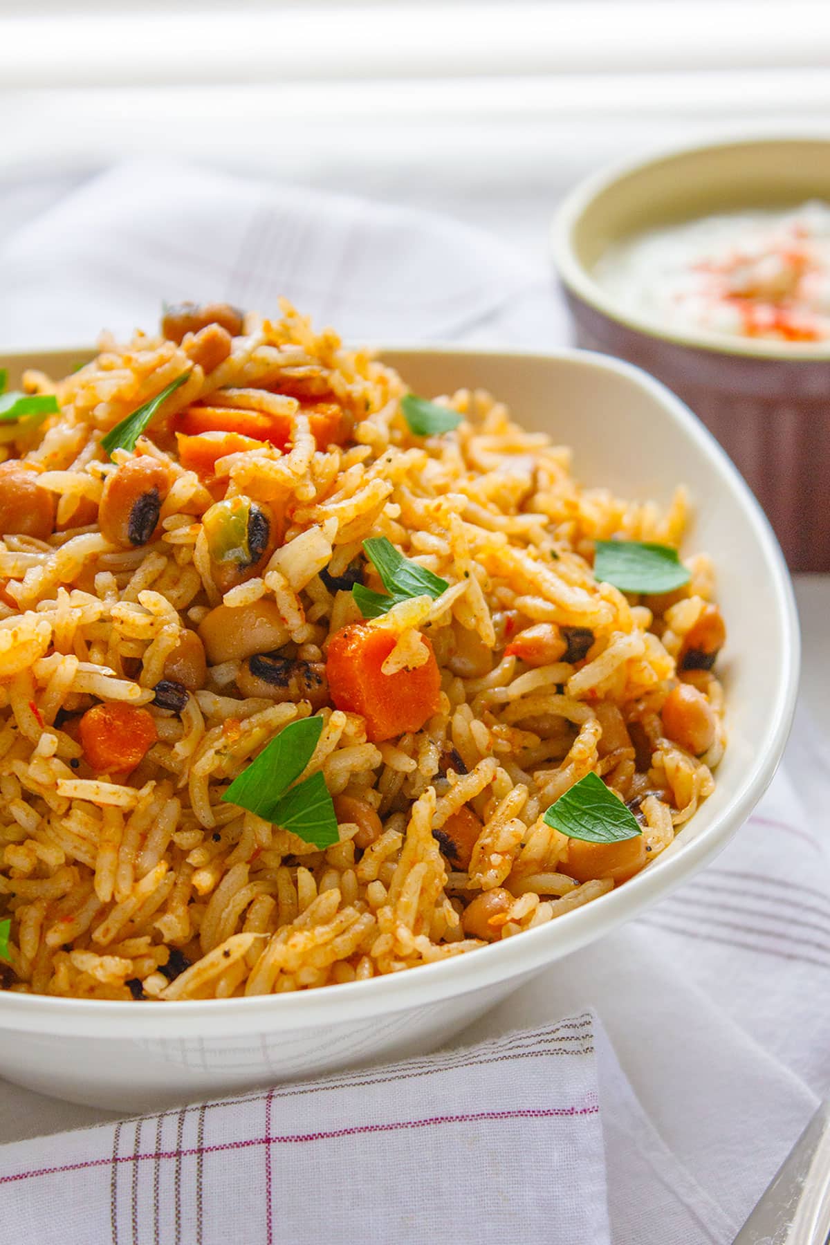 Close up image of black eyed peas with rice in a white bowl.