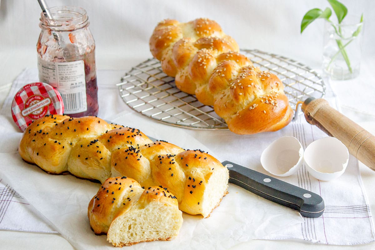 Braided milk bread next to jam bottle.