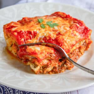 Classic beef lasagna with a fork. Feature image.