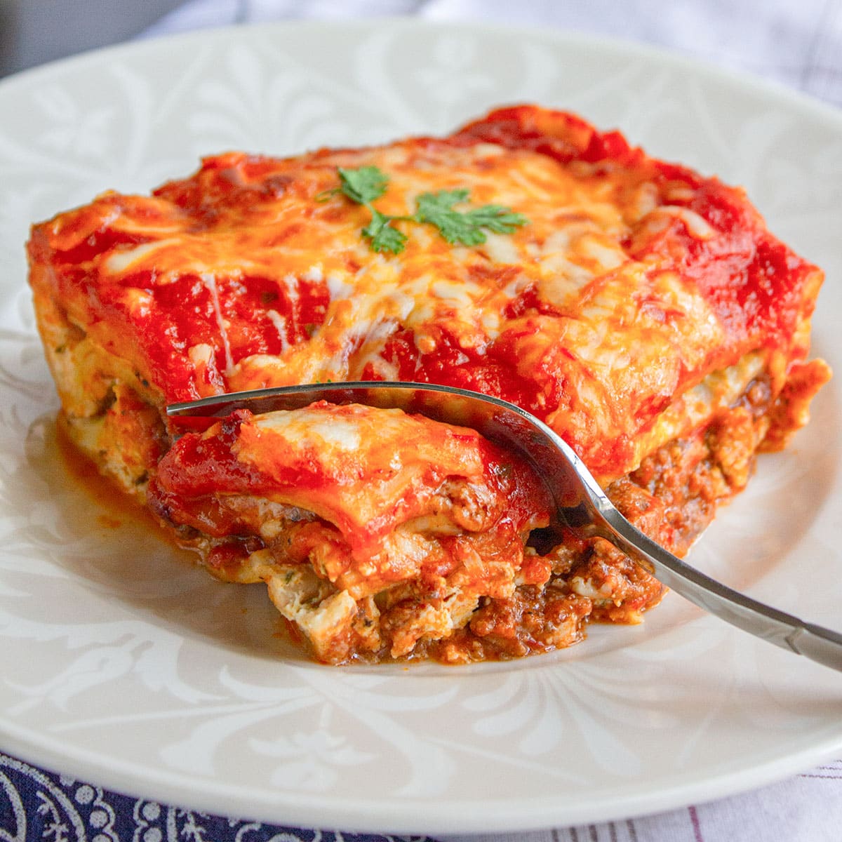 Classic beef lasagna with a fork. Feature image.