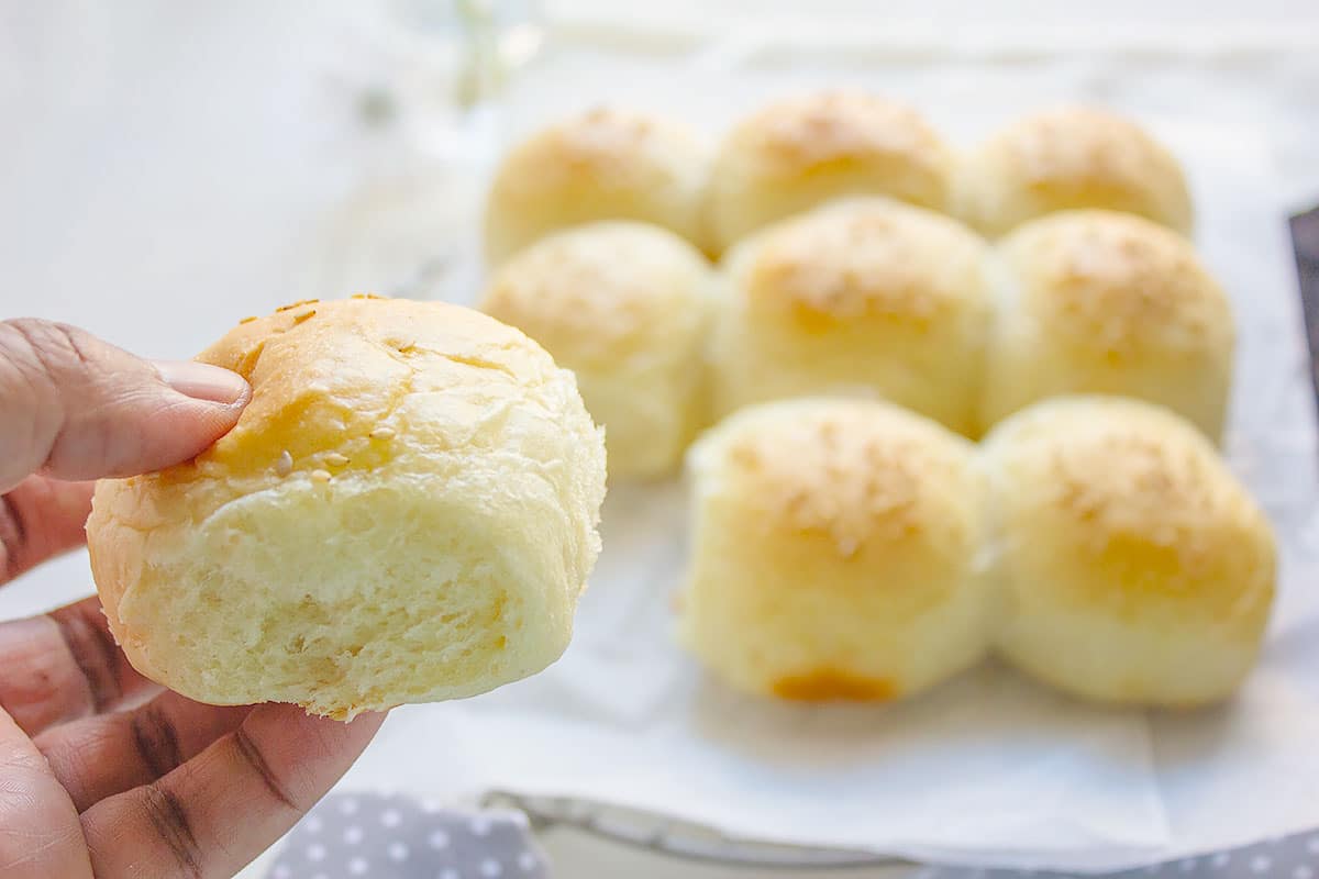 Fluffy homemade dinner rolls held in a hand.
