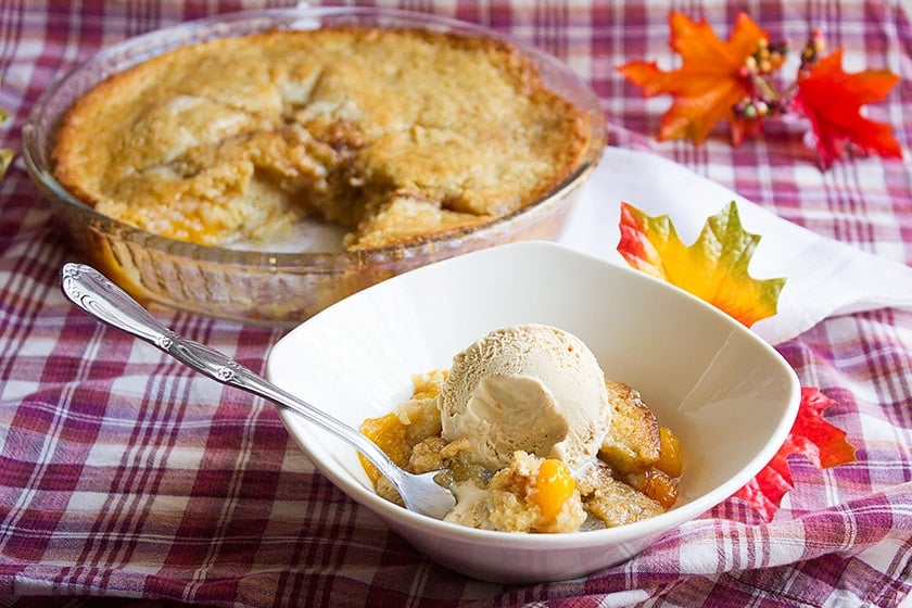 Peach cobbler served with a bog scoop of ice cream.
