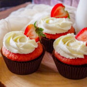 Strawberry cupcakes frosted with buttercream and garnished with slice of strawberry.