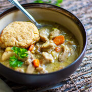 Chicken and dumplings served in a brown bowl.