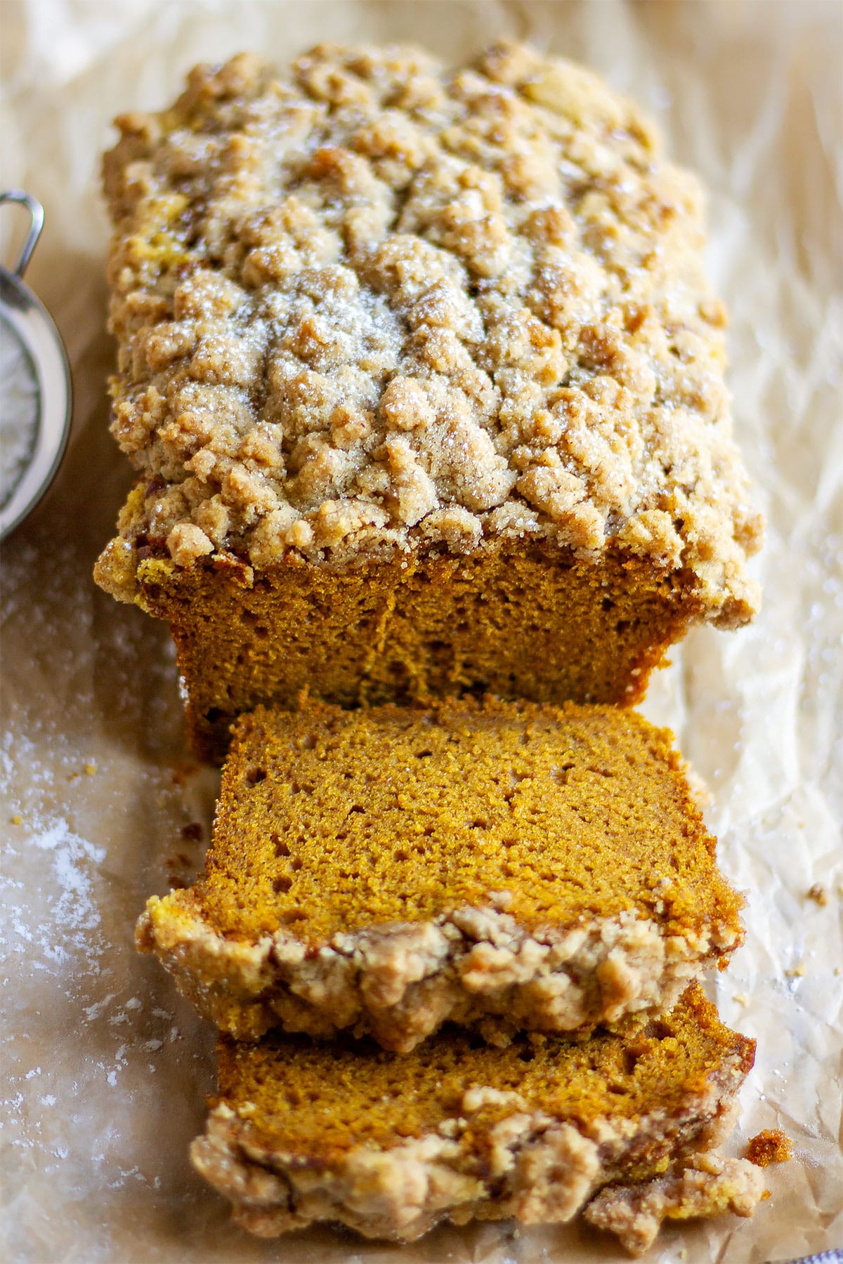 Slices of pumpkin crumb cake on brown paper. 