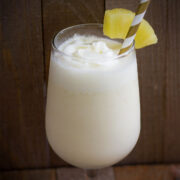 Virgin pina colada served in a glass with a straw.