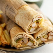 Chicken Shawarma Wrapped in parchment paper and served on a plate.