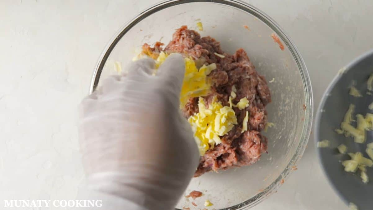 Adding butter to the meat mixture.