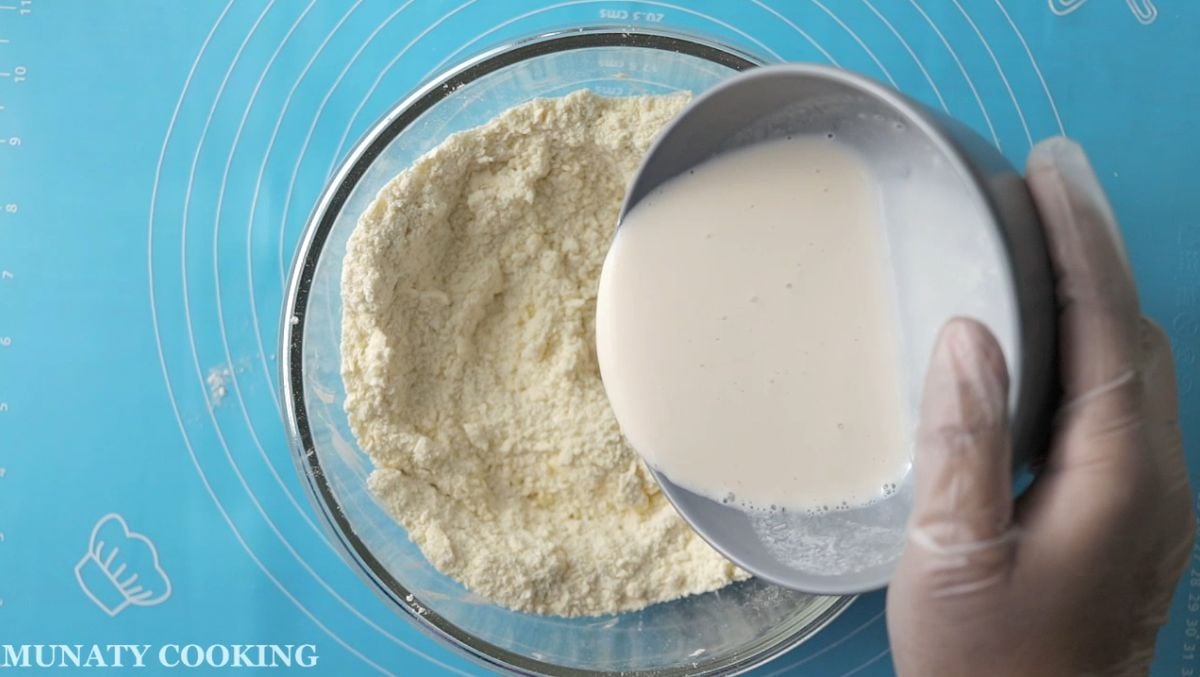 Adding buttermilk to the flour and butter mixture.