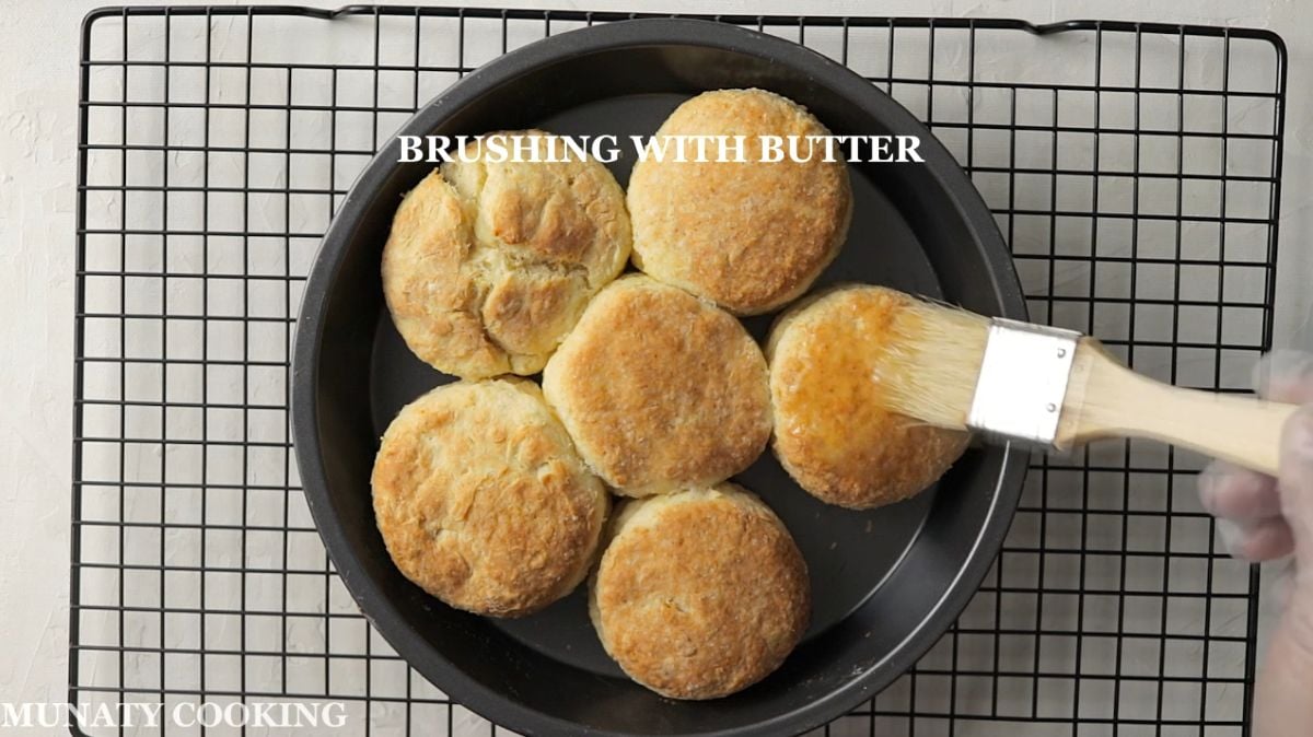 Brushing the biscuits with melted butter.