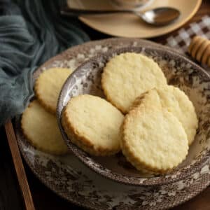 Coconut cookies sandwich with honey in the middle served in a plate.