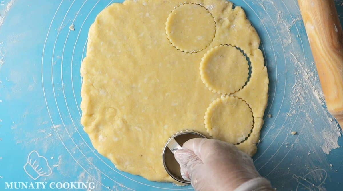 Cutting the cookie dough with a cookie cutter.