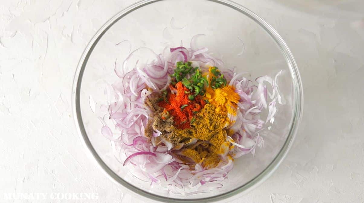 Mixing the onion with the spices in a bowl.