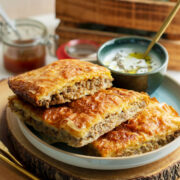 Egyptian Goulash served on a plate with yogurt dip on the side.