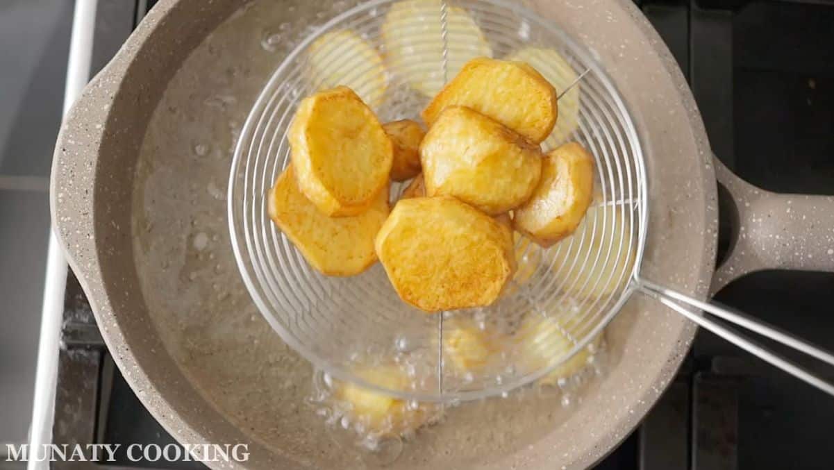 Frying the sliced potatoes.