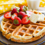 Fluffy Buttermilk Waffles, crispy from the outside fluffy from the inside. Served with butter and strawberries.