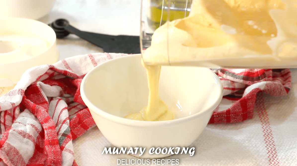 Pouring hummus in a bowl.