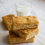 Freshly prepared butterscotch blondies served with a glass of milk.