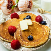 Fluffy sour cream pancakes served with strawberries.