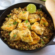 Sayadieh served in a cast iron skillet, garnished with slice of lime.