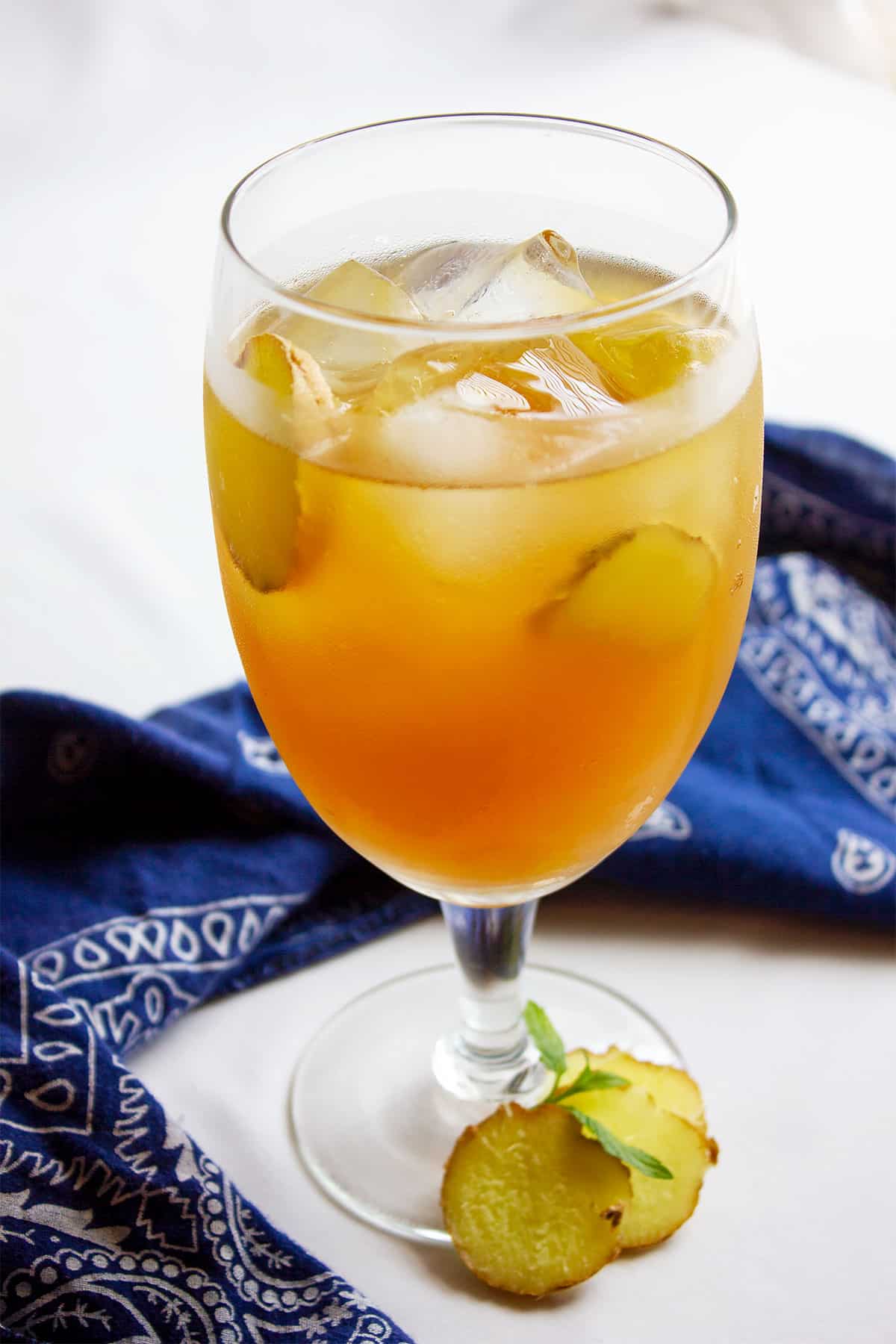 Ginger tea in a glass with ginger slices.