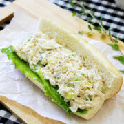 Chicken salad sandwich freshly prepared on parchment paper.