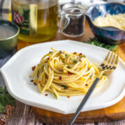 Close image of spaghetti aglio e Olio served on a white plate.