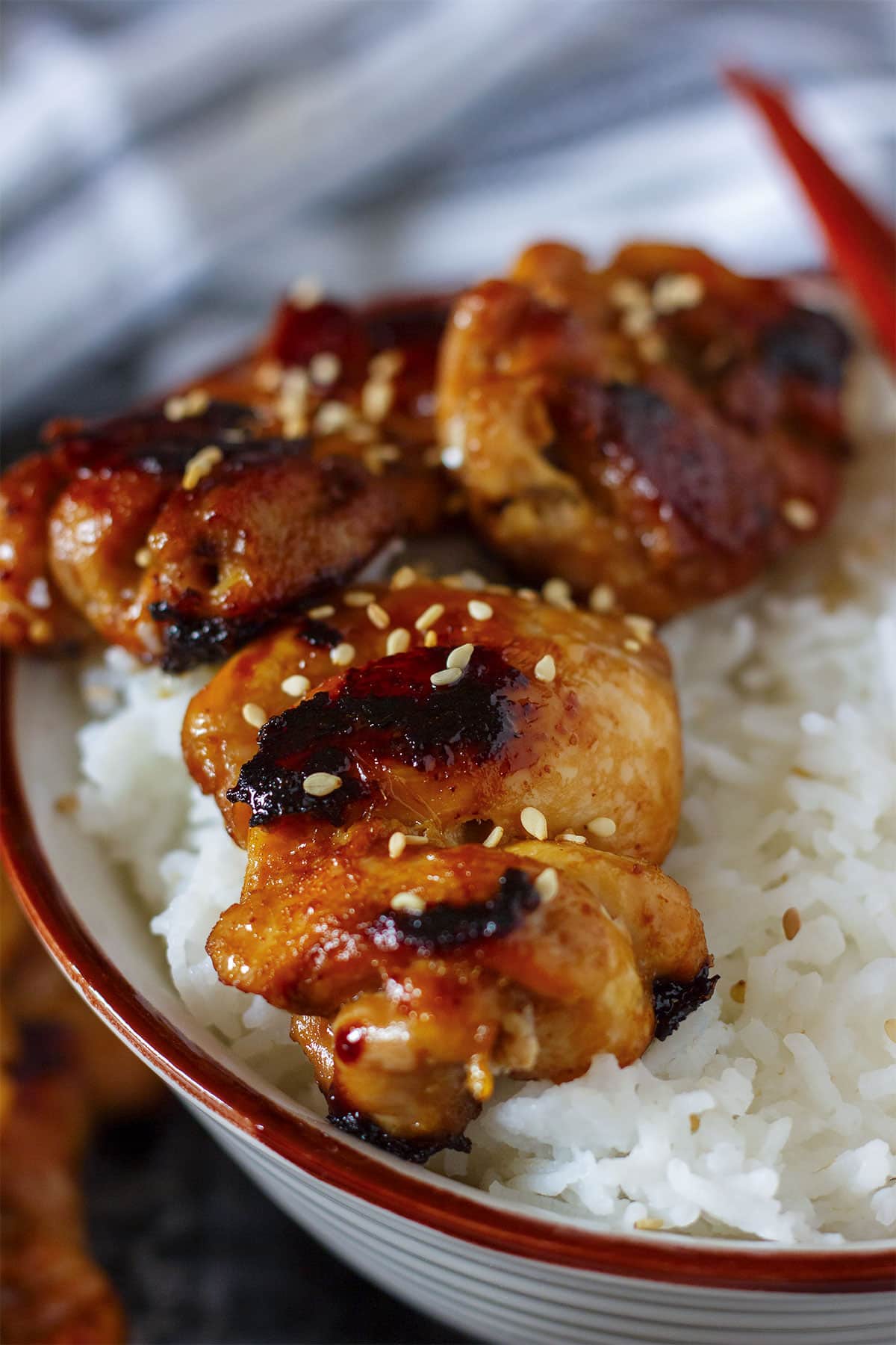 Close up image of Teriyaki chicken skewers served on rice.