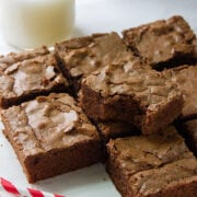Fudge brownies squares on white parchment paper.