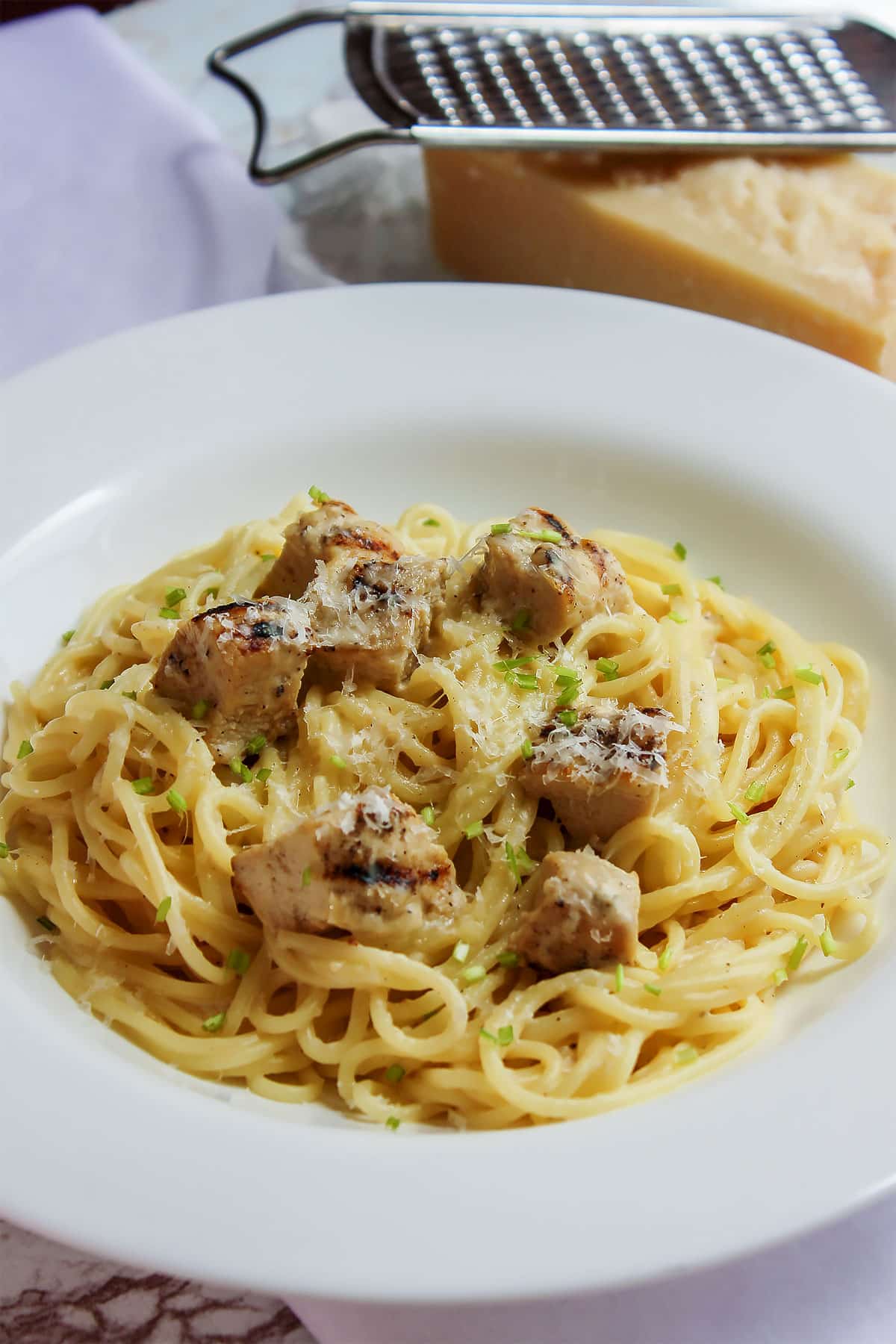 Close up image of low calorie chicken alfredo served in white plate.