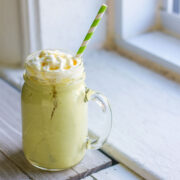 Avocado banana smoothie in a mason jar with wipped cream.
