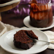 Close up image of moist chocolate bundt cake. A slice of cake on a white plate.