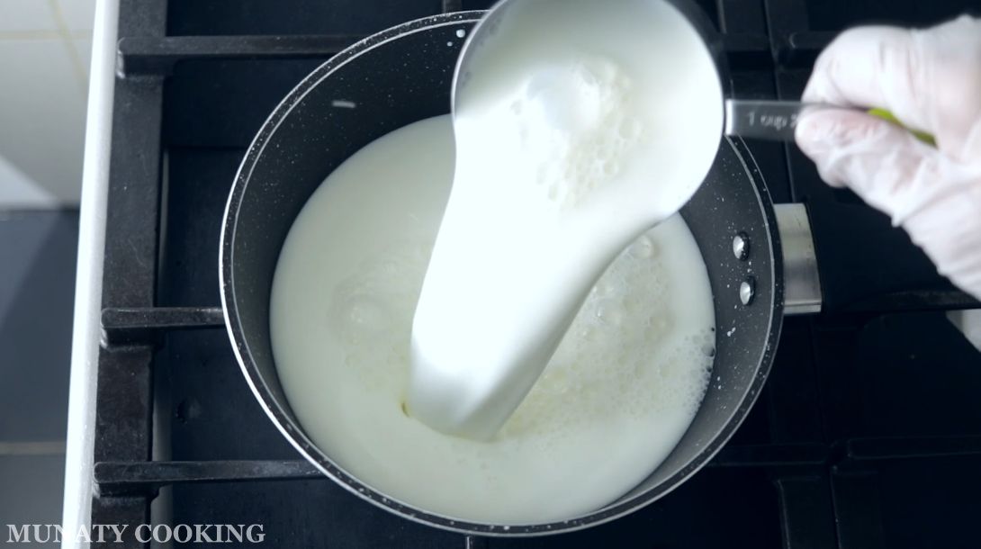 Pouring whole milk into pot.