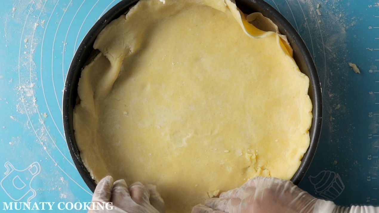 Placing the pie crust in the baking pan.