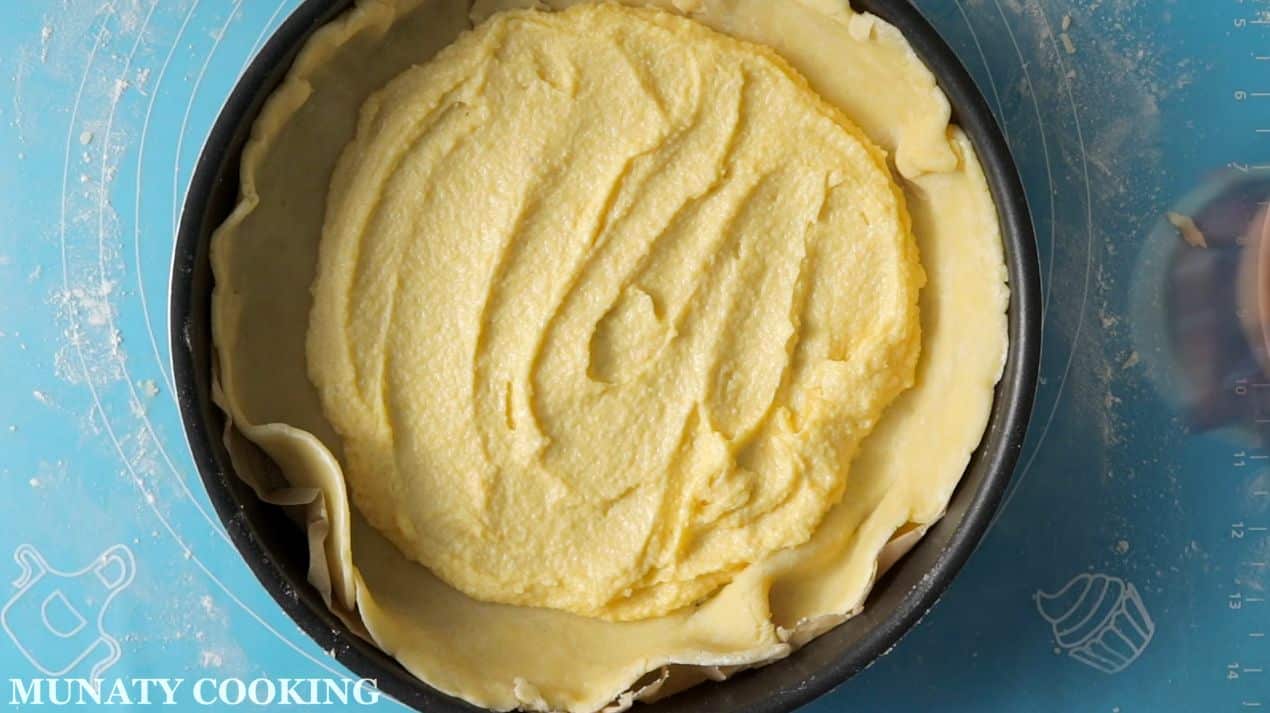 Spreading the frengipane on the pie crust.