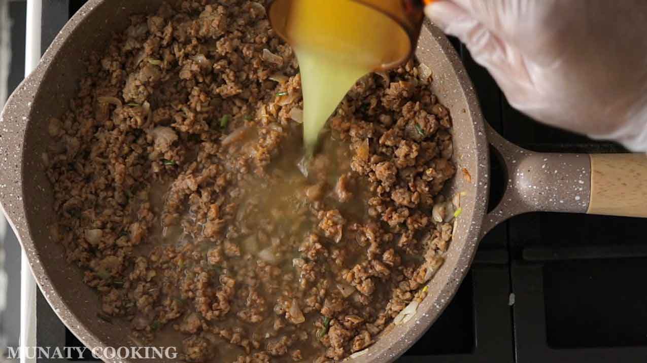 Adding broth to the meat filling.
