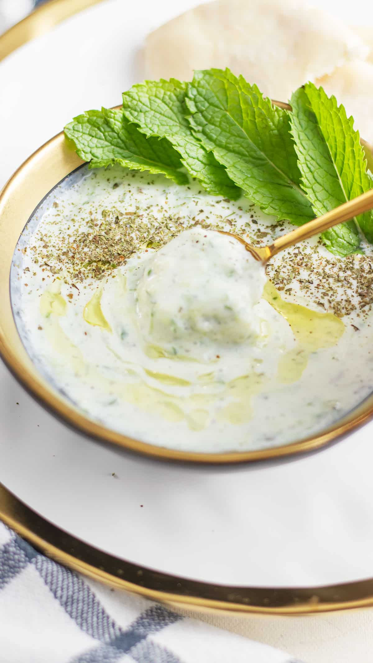 Golden spoon in the cucumber yogurt salad bowl.