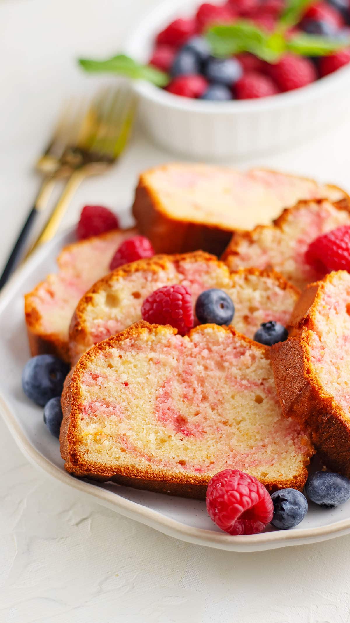 close up image of raspberry swirl cake freshly prepared and served with some  fresh berries.